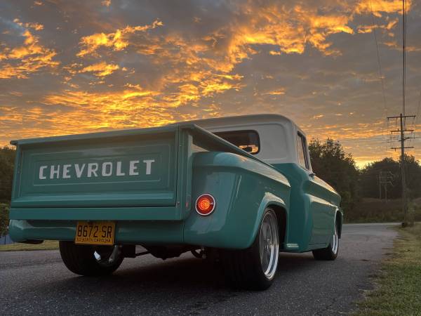 Rear three-quarter view of the completed turquoise 1962 Chevrolet C10 at sunset